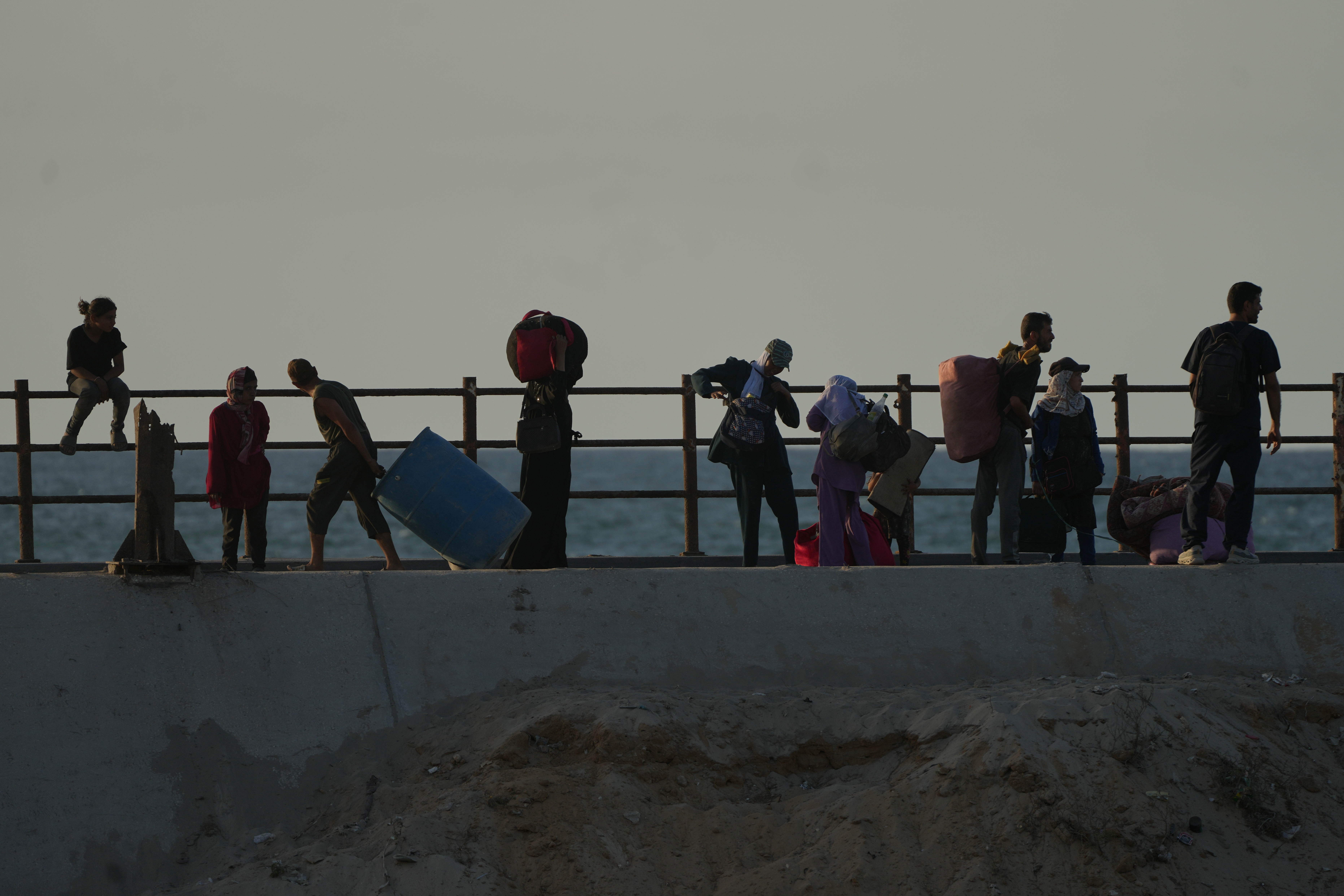 Displaced Palestinians flee northern Gaza carrying their belongings along the coastal road near Wadi Gaza, Thursday, Oct. 2, 2025.